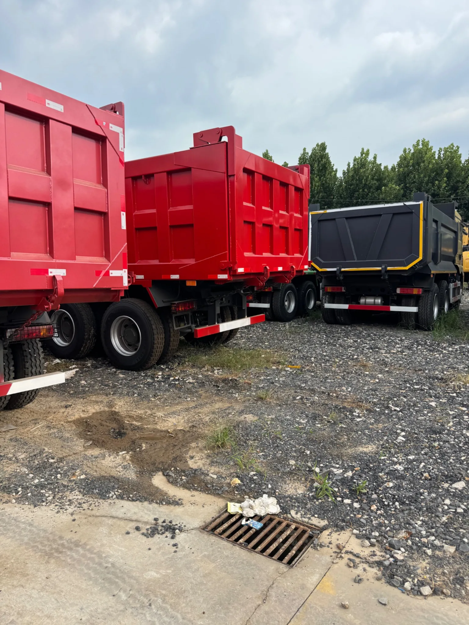 Multiple used dump trucks in machinery stock yard