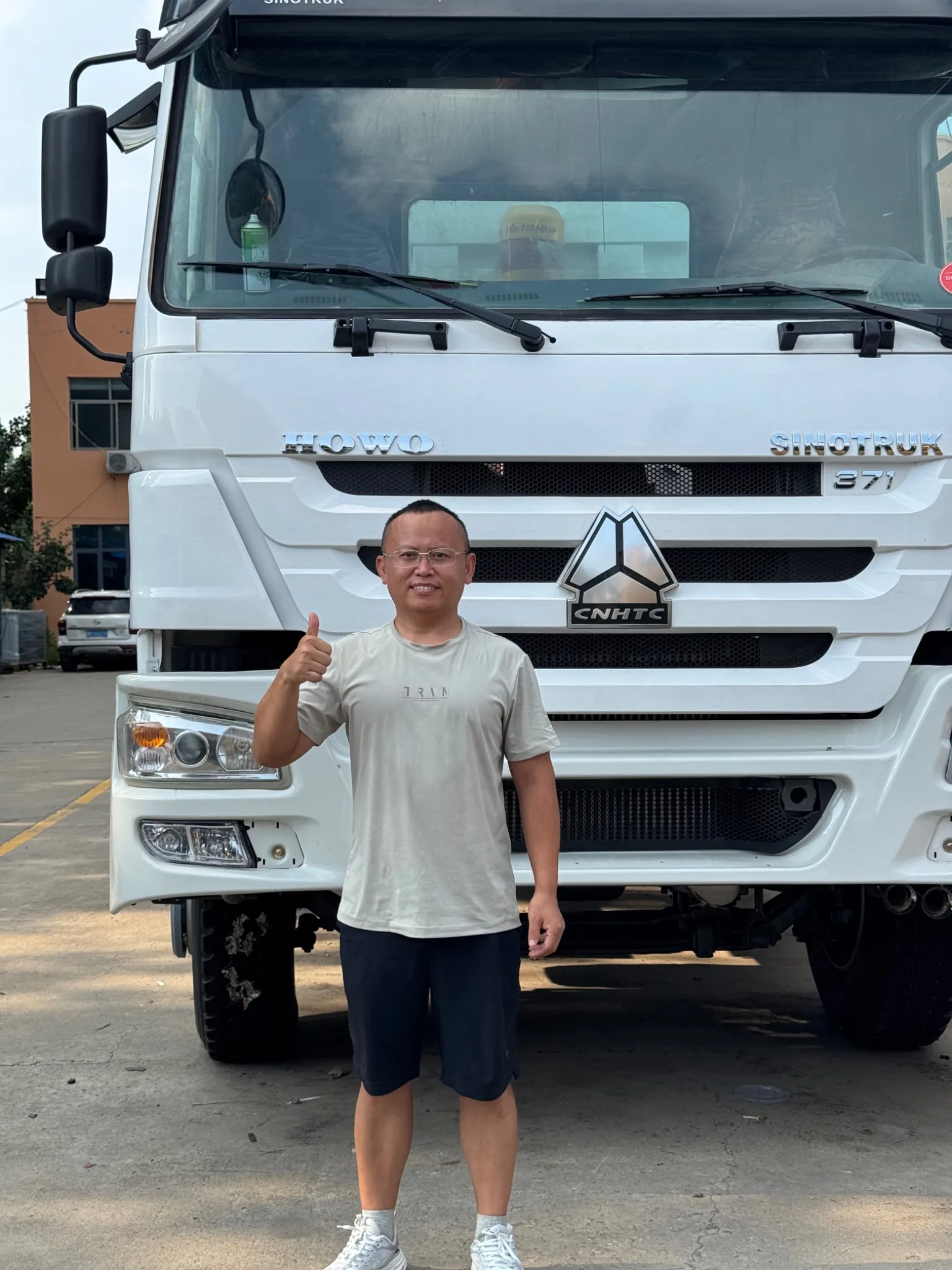 Sales contact standing in front of a used HOWO dump truck
